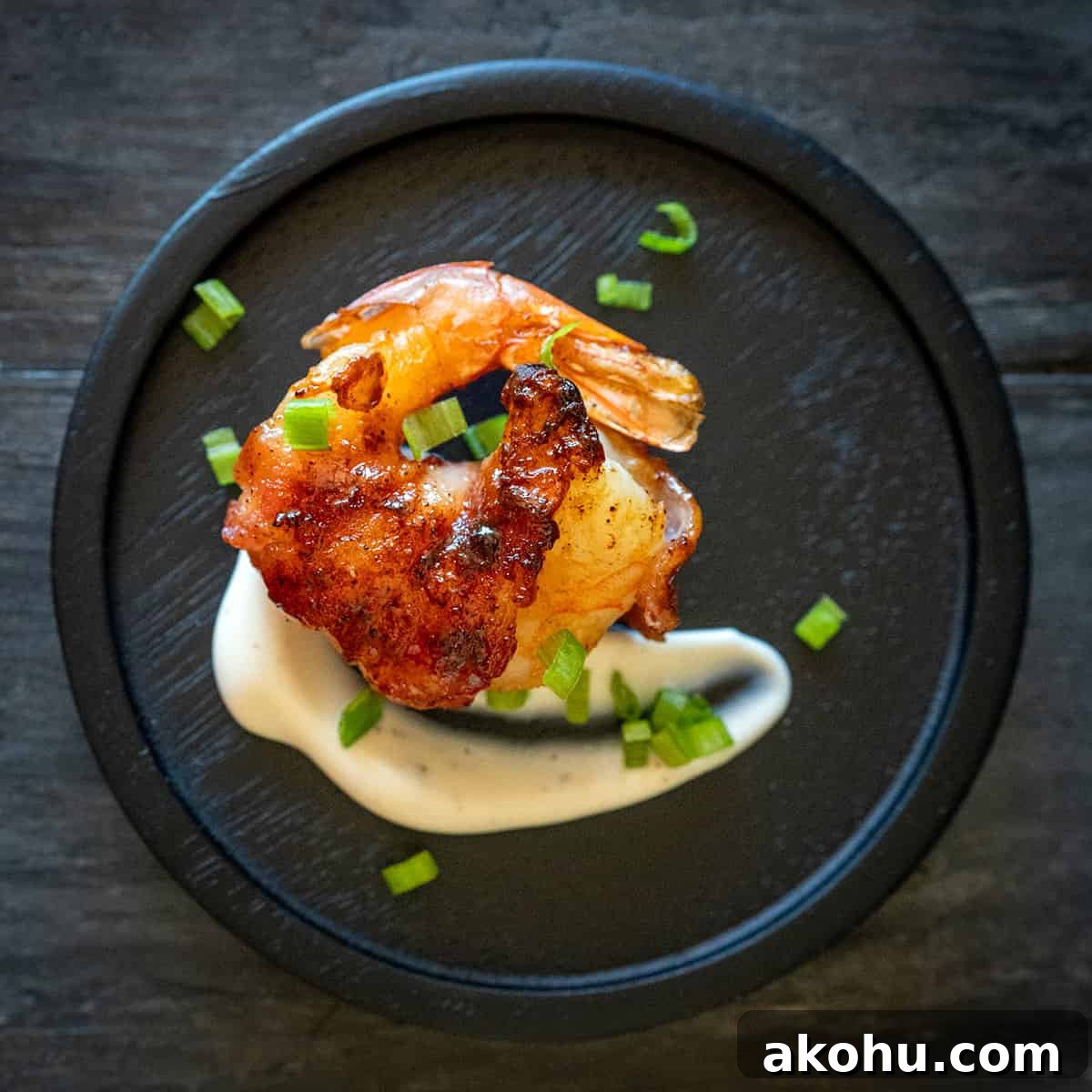 Curly bacon wrapped shrimp on plate with aioli.