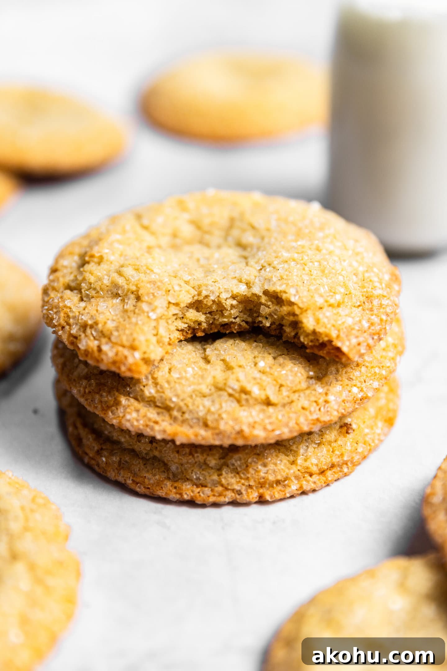 Drop-Style Vanilla Sugar Cookies: Quick Classic Recipe 3 Sugar cookies stacked on top of each other next to a glass of milk. There's a bite missing from the top cookie.