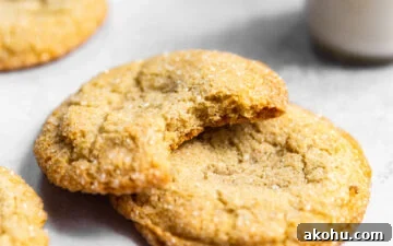 Drop-Style Vanilla Sugar Cookies: Quick Classic Recipe 10 Sugar cookies stacked on top of each other with a bite missing from one next to a glass of milk.