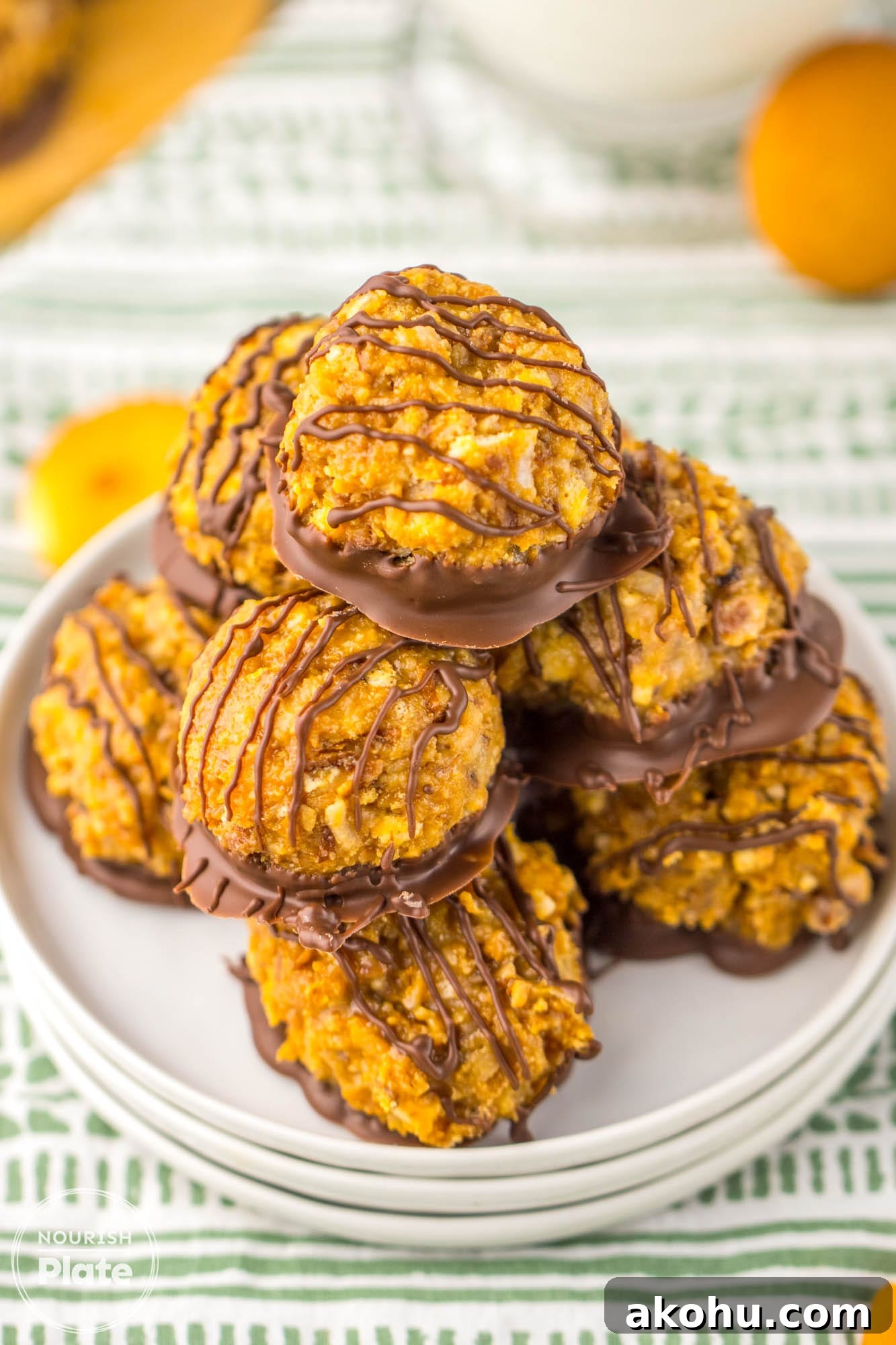 Stacked Samoas truffles on a white plate, with a glass of milk in the background