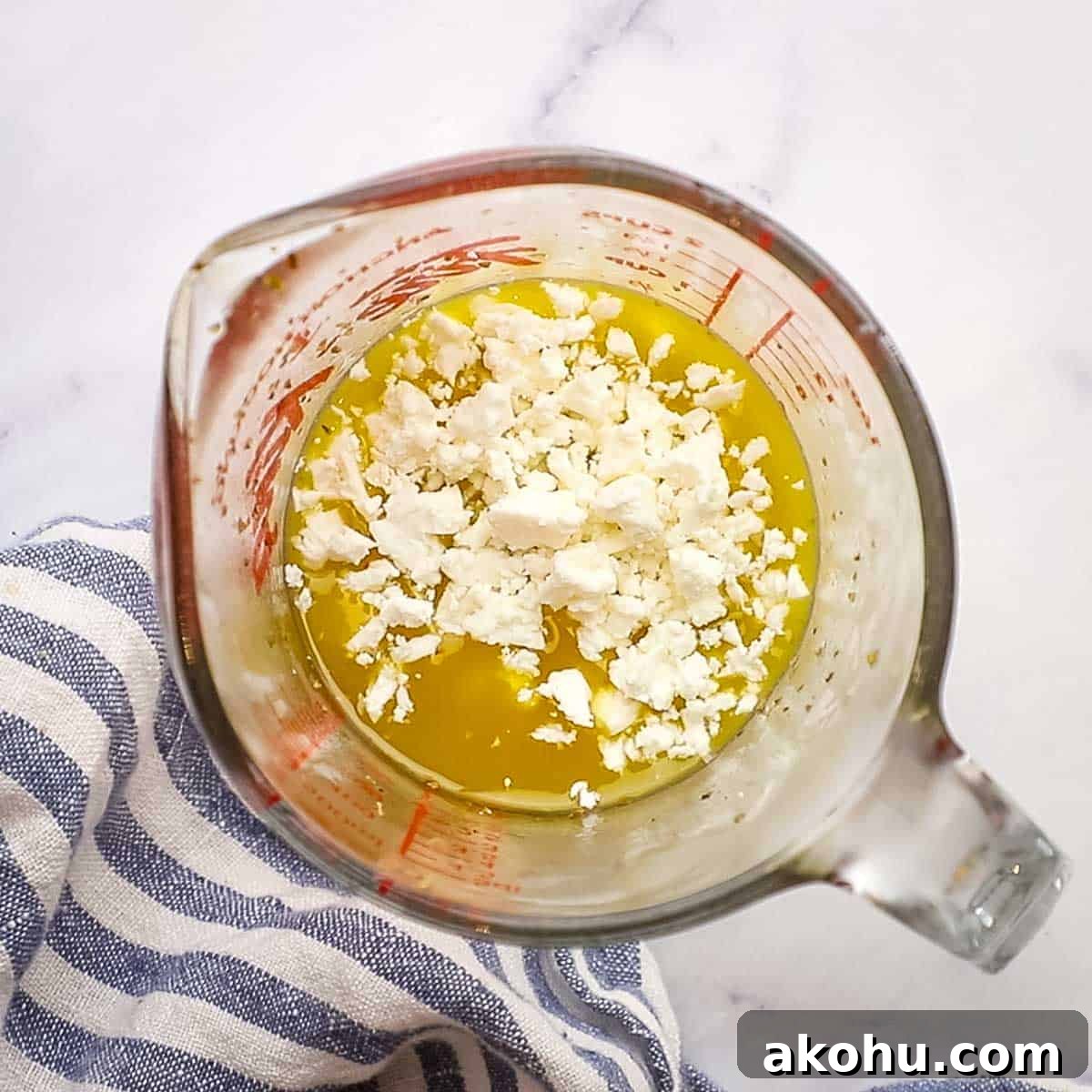 Greek Chicken Salad with Feta, Olives & Lemon Vinaigrette 8 adding crumbled feta cheese to the greek marinade