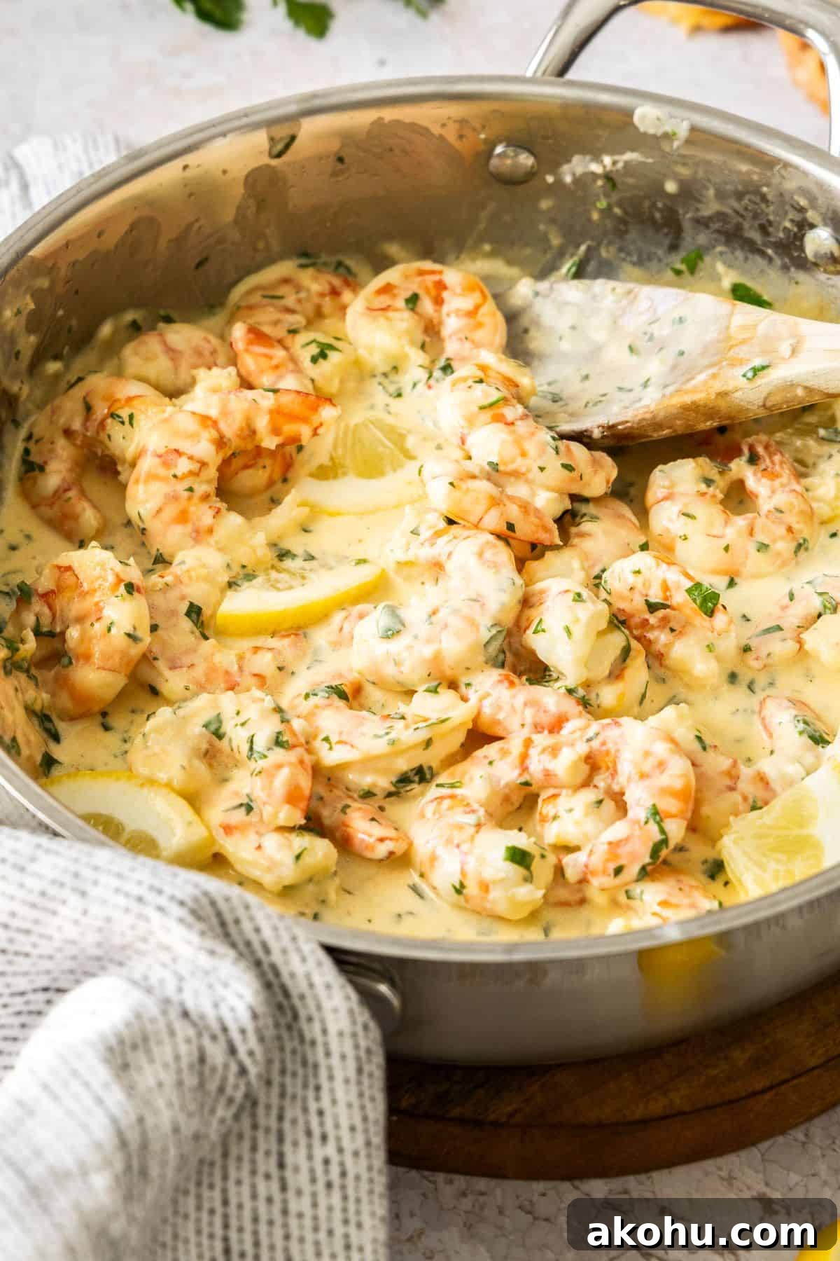 Easter Dinner Mains: Elegant Roast and Ham Recipes 10 Frying pan with Creamy Lemon Prawns, and a wooden spoon resting in the pan.