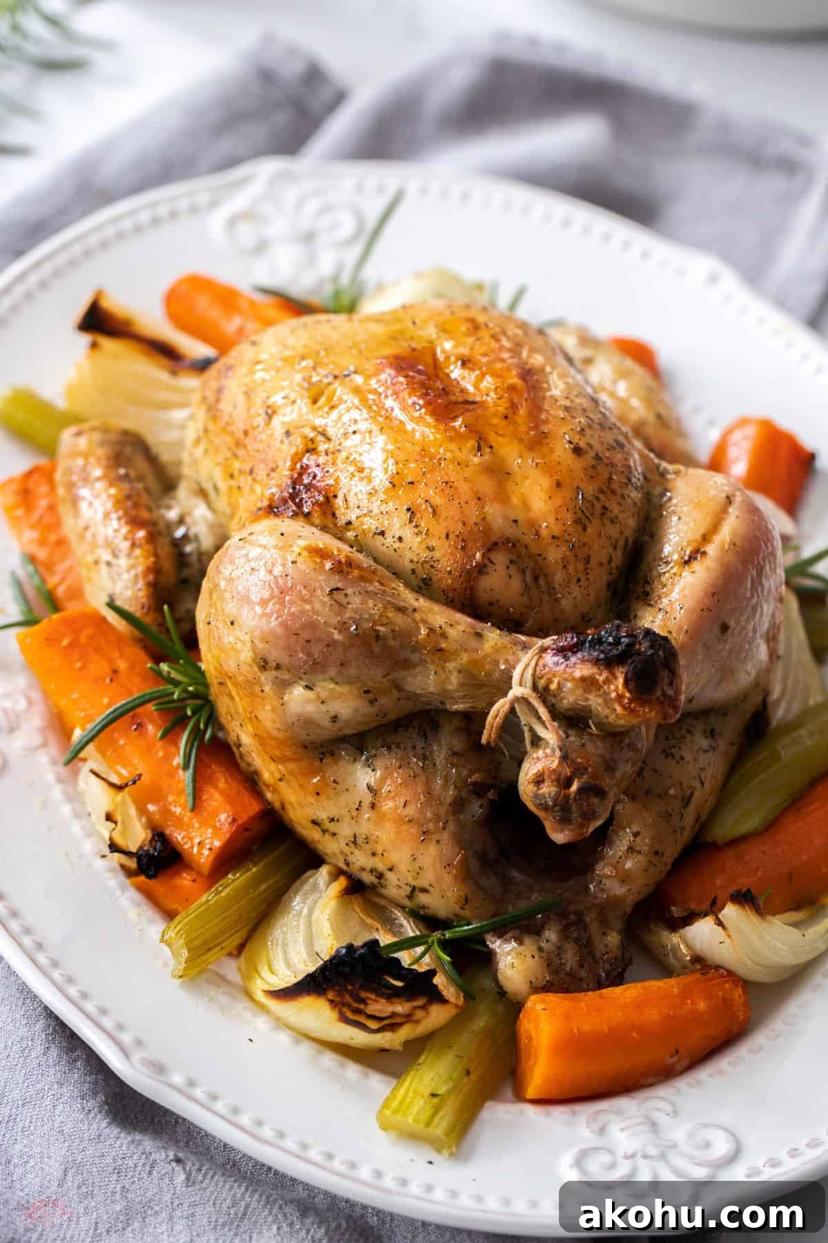 Easter Dinner Mains: Elegant Roast and Ham Recipes 16 White oval plate with Roast Chicken in the centre, and some vegetables around the edge.