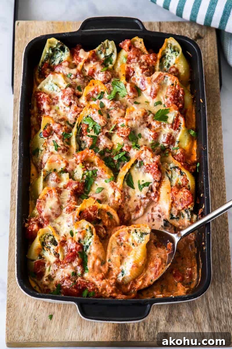 Easter Dinner Mains: Elegant Roast and Ham Recipes 18 Dish of Spinach and Ricotta Pasta Shells, with a spoon.