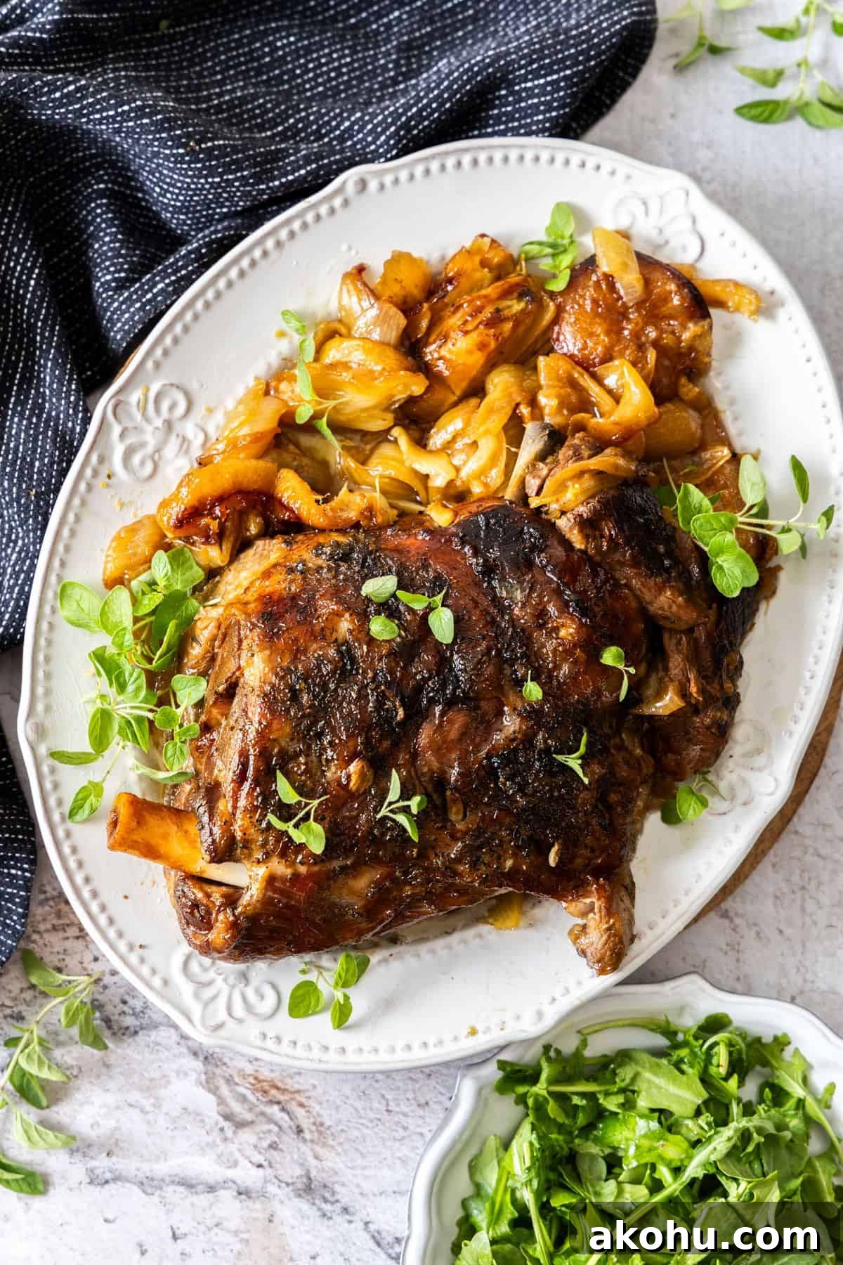 Easter Dinner Mains: Elegant Roast and Ham Recipes 3 Large white platter with the Slow Roasted Lamb Shoulder, garnished with the roasted lemon, fennel and fresh oregano.