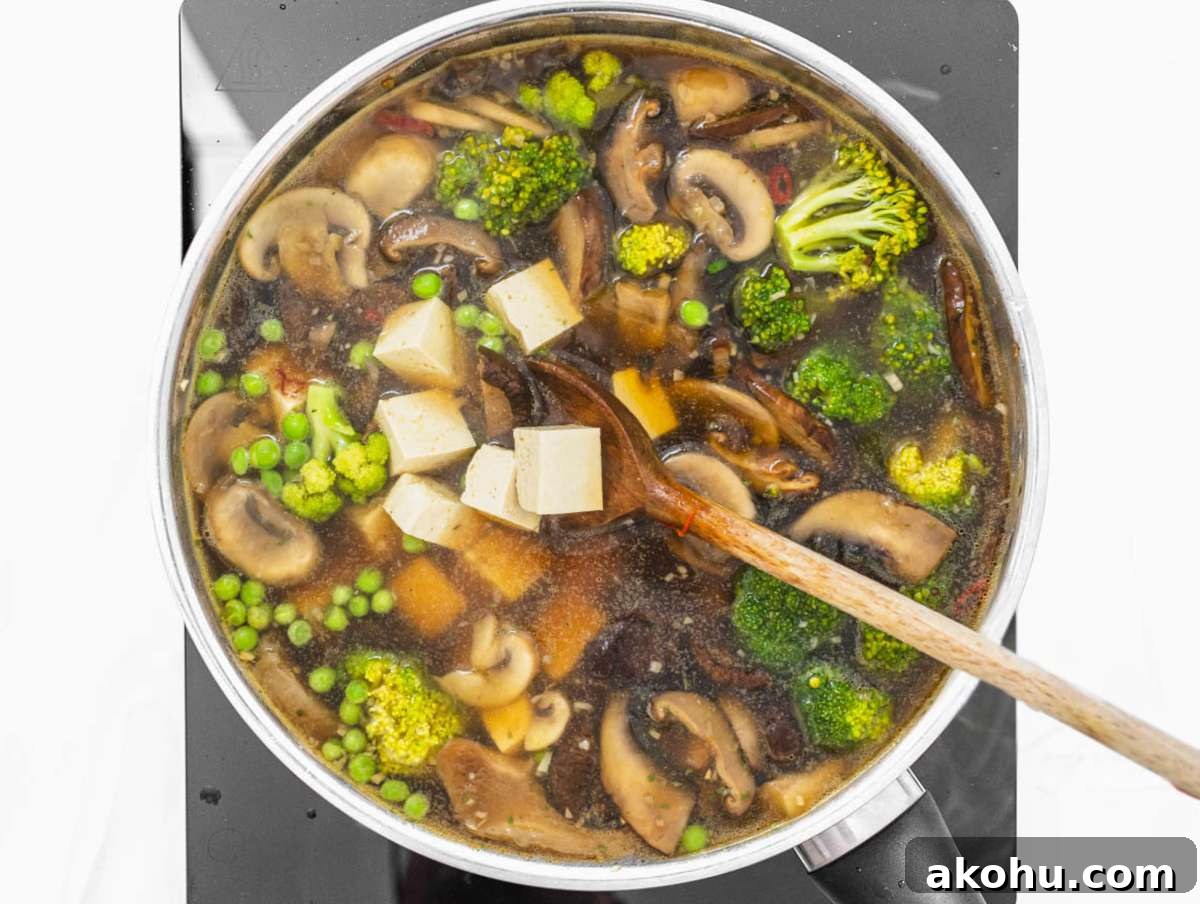 Step 2 Tofu broccoli peas and broth simmering together for easy one pot tofu soup.