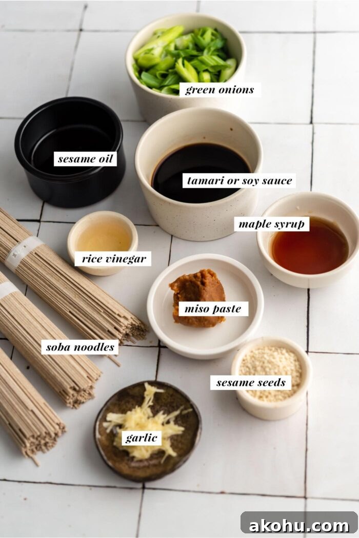 All the ingredients gathered for making a hot or cold sesame soba noodle salad with green onions. Each ingredient is labelled with text describing it.