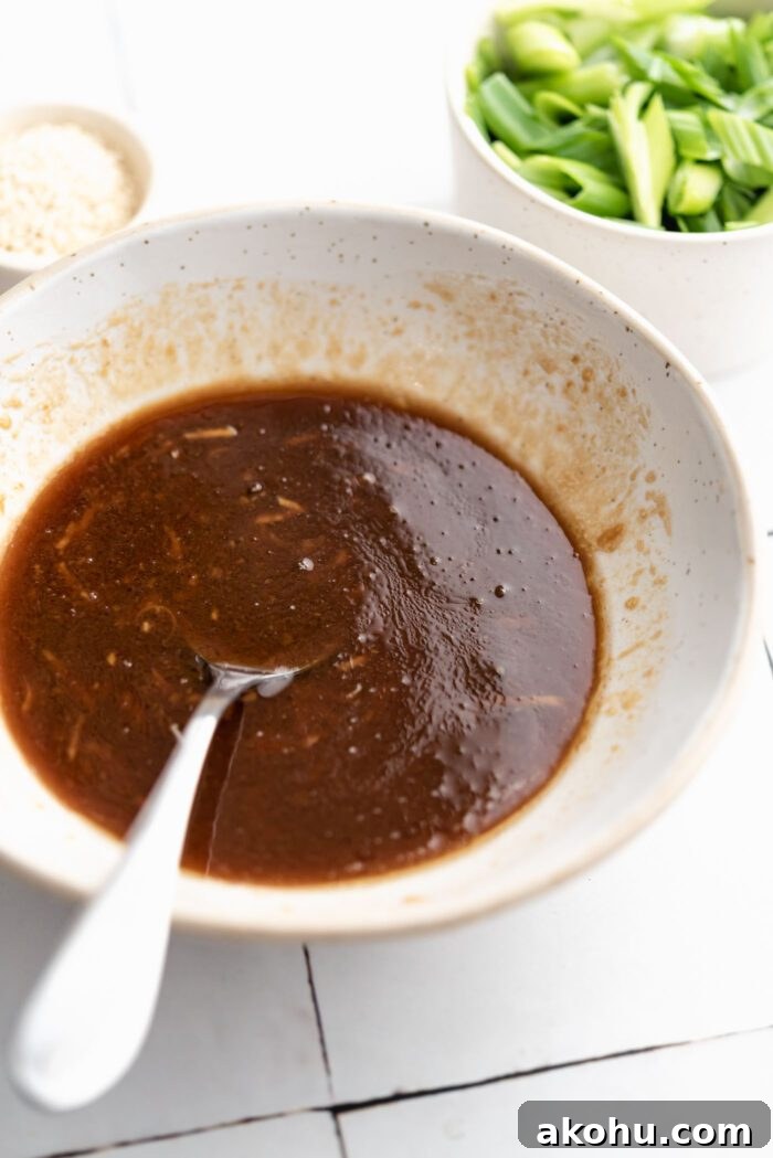 Sesame miso garlic sauce mixed together in a small bowl. A spoon rests in the bowl.