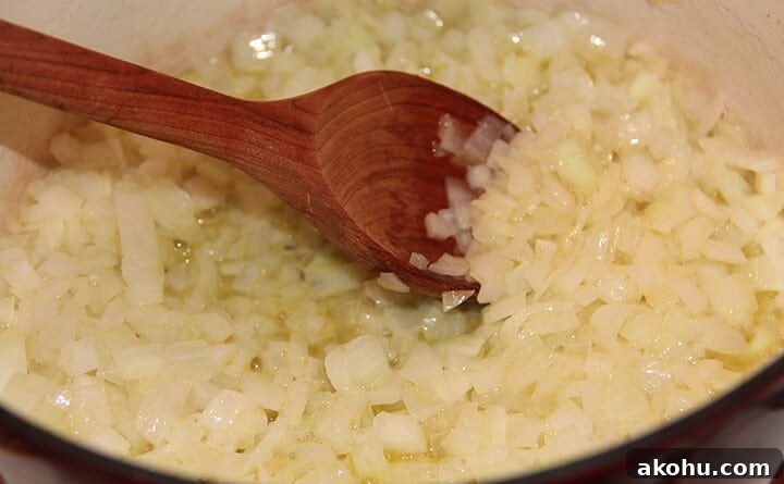 Onions sauteing in a pot to make homemade tomato soup.