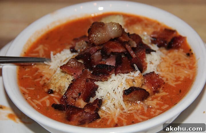 Easy Tomato Soup recipe topped with bacon and parmesan cheese.
