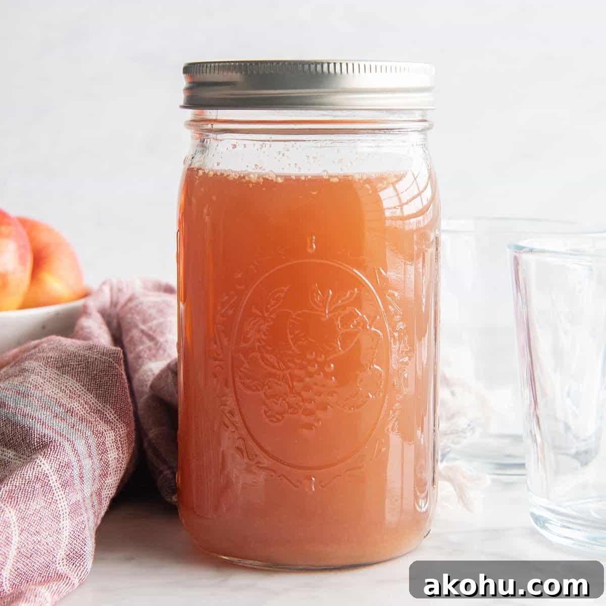 A glass jar with a lid filled with homemade apple cider