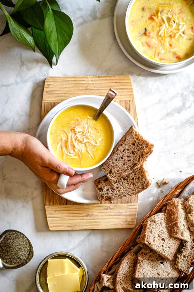 A hand is holding the mug of instant pot ham and potato soup