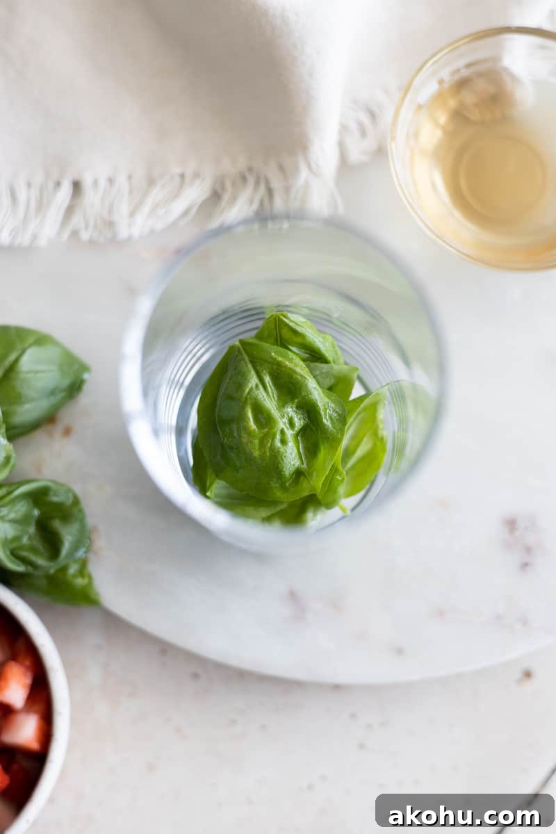 Basil in the bottom of a highball glass. 