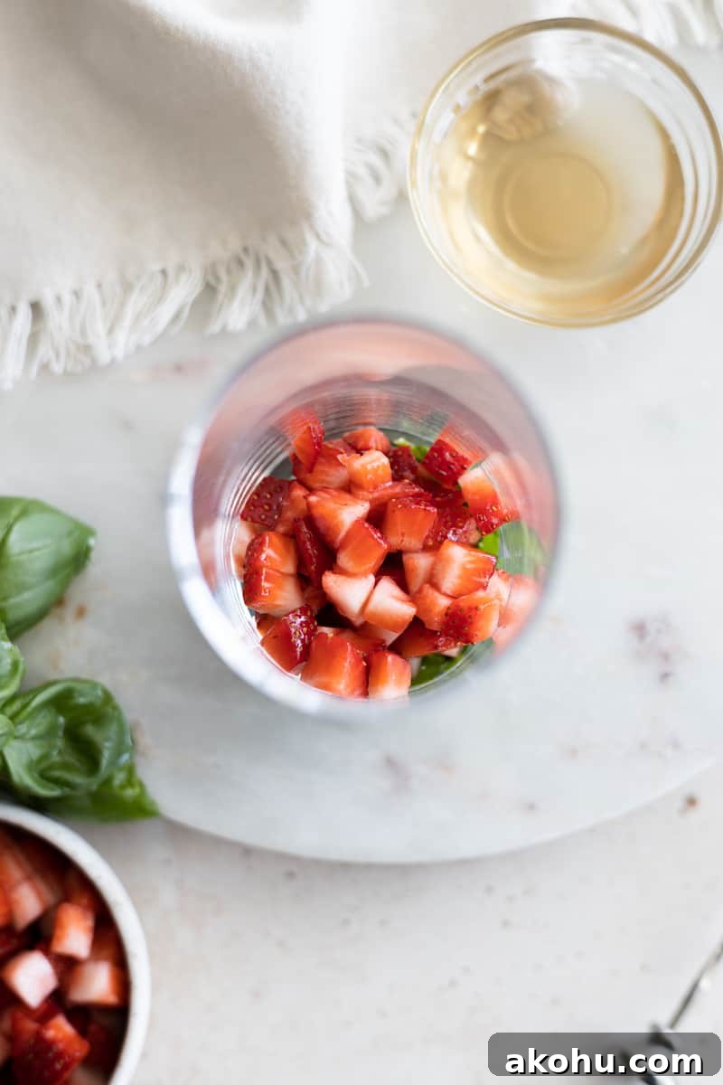 Strawberries in the bottom of a highball glass. 
