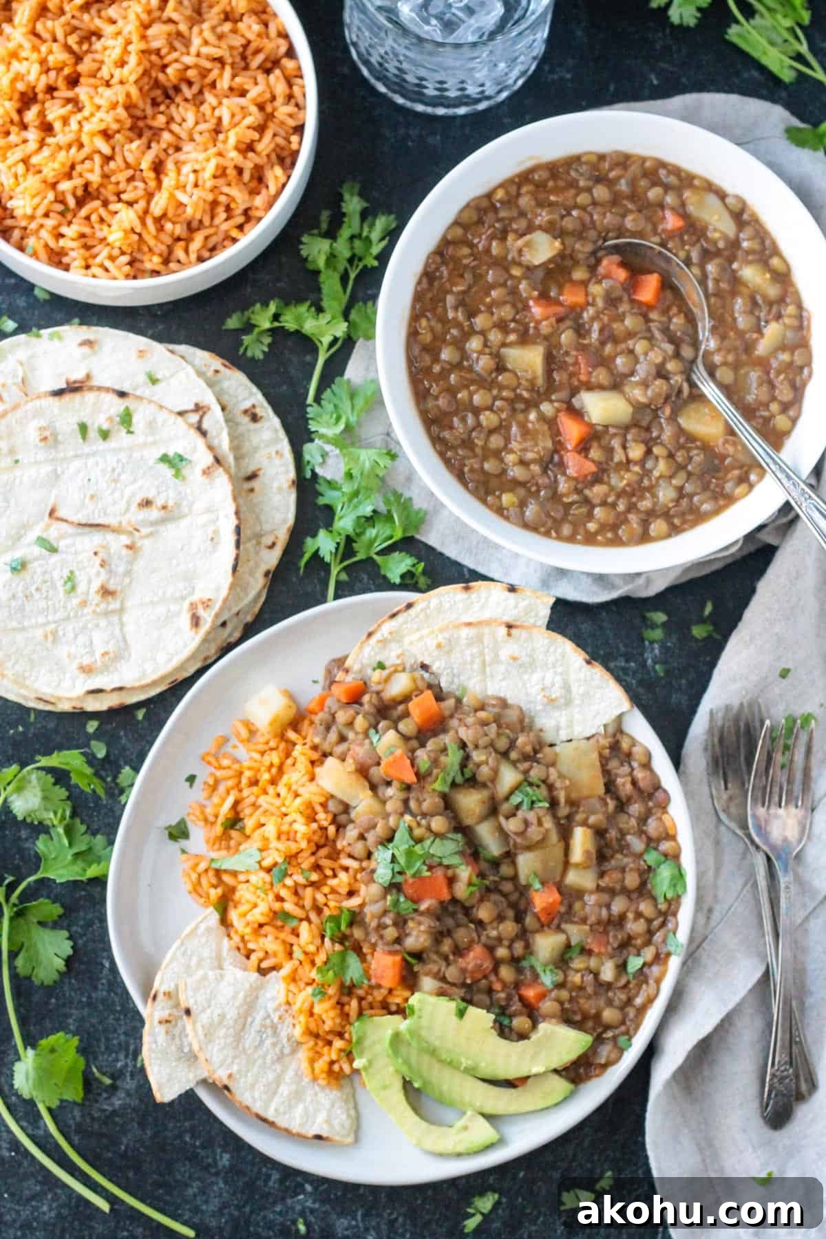 Vegan picadillo on a plate with Mexican rice next a pile of corn tortillas and fresh cilantro.
