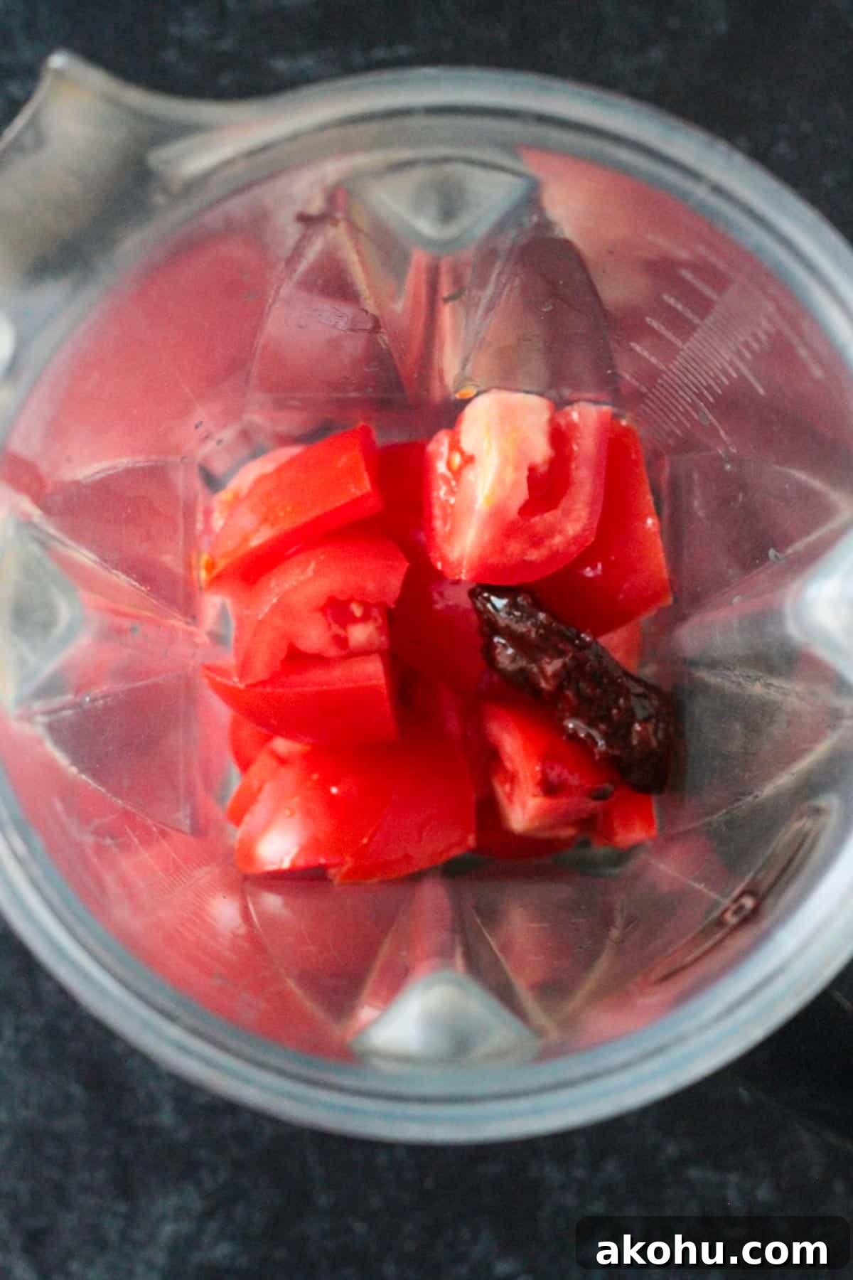 Chopped roma tomatoes in a blender with a chipotle in adobo.