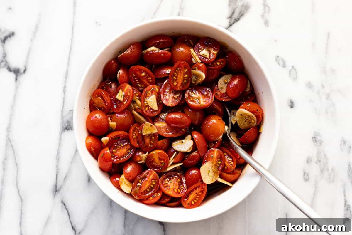 Marinated tomatoes and garlic in a white bowl.