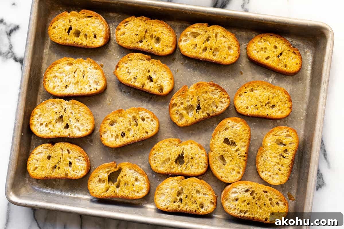 Homemade crostini on a large metal baking sheet.
