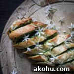 Freshly baked golden garlic bread scattered with retry white wild garlic flowers