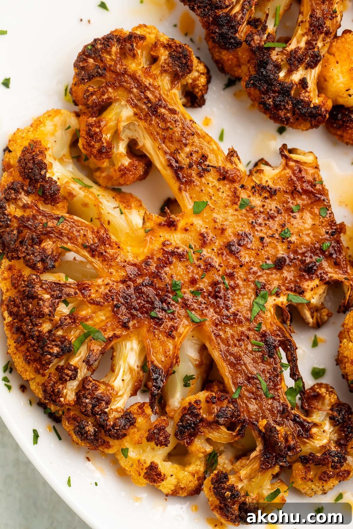 A roasted cauliflower steak on a white plate.