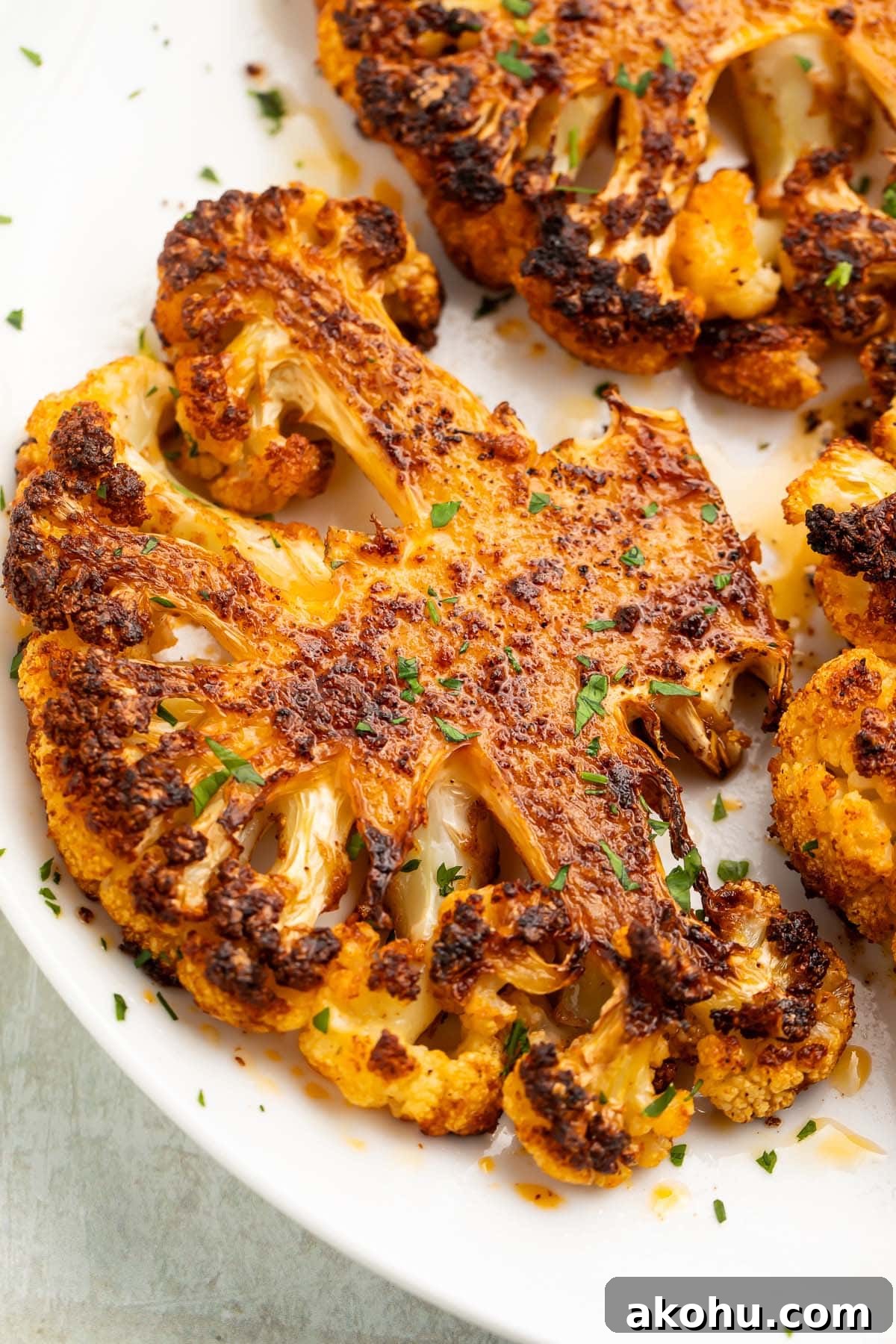 A roasted cauliflower steak on a white plate.