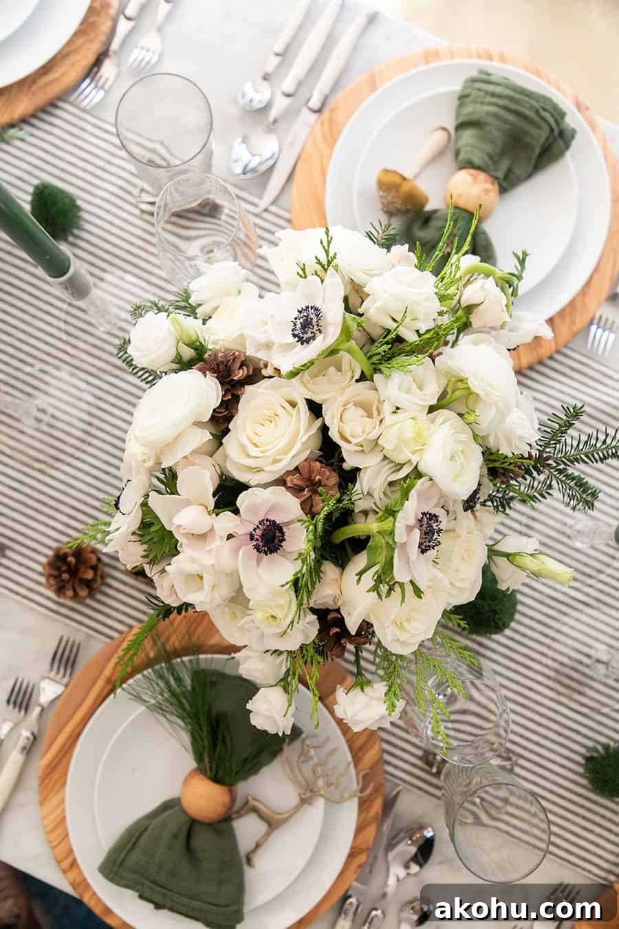 Christmas flower arrangement on a table with striped linen table runner.