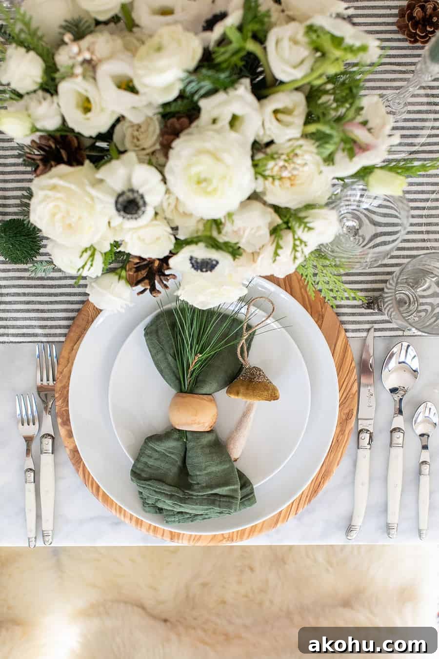 Christmas table setting, green napkin, olive wood charger, white plates from Williams Sonoma.