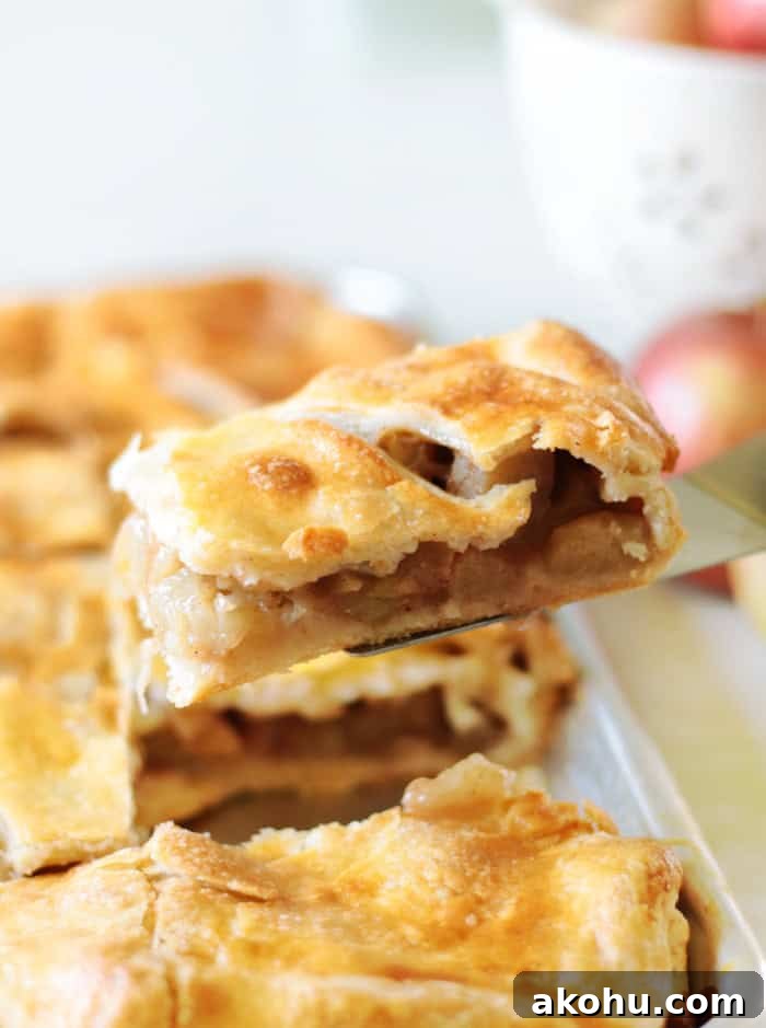 Slice of apple slab pie on spatula.