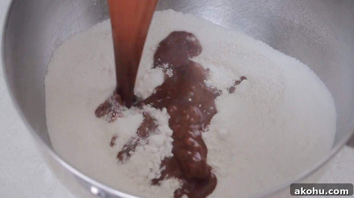 Ultimate Texas Sheet Cake Recipe for Rich Chocolate Dessert 6 Chocolate and butter mixture poured over the flour mixture in a metal mixing bowl.