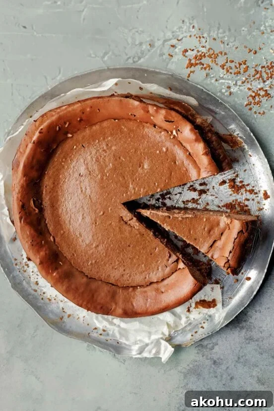 Basque Cheesecake with Tangy Pomegranate Molasses Glaze 17 A whole espresso cheesecake on a silver tray with two slices cut from it.