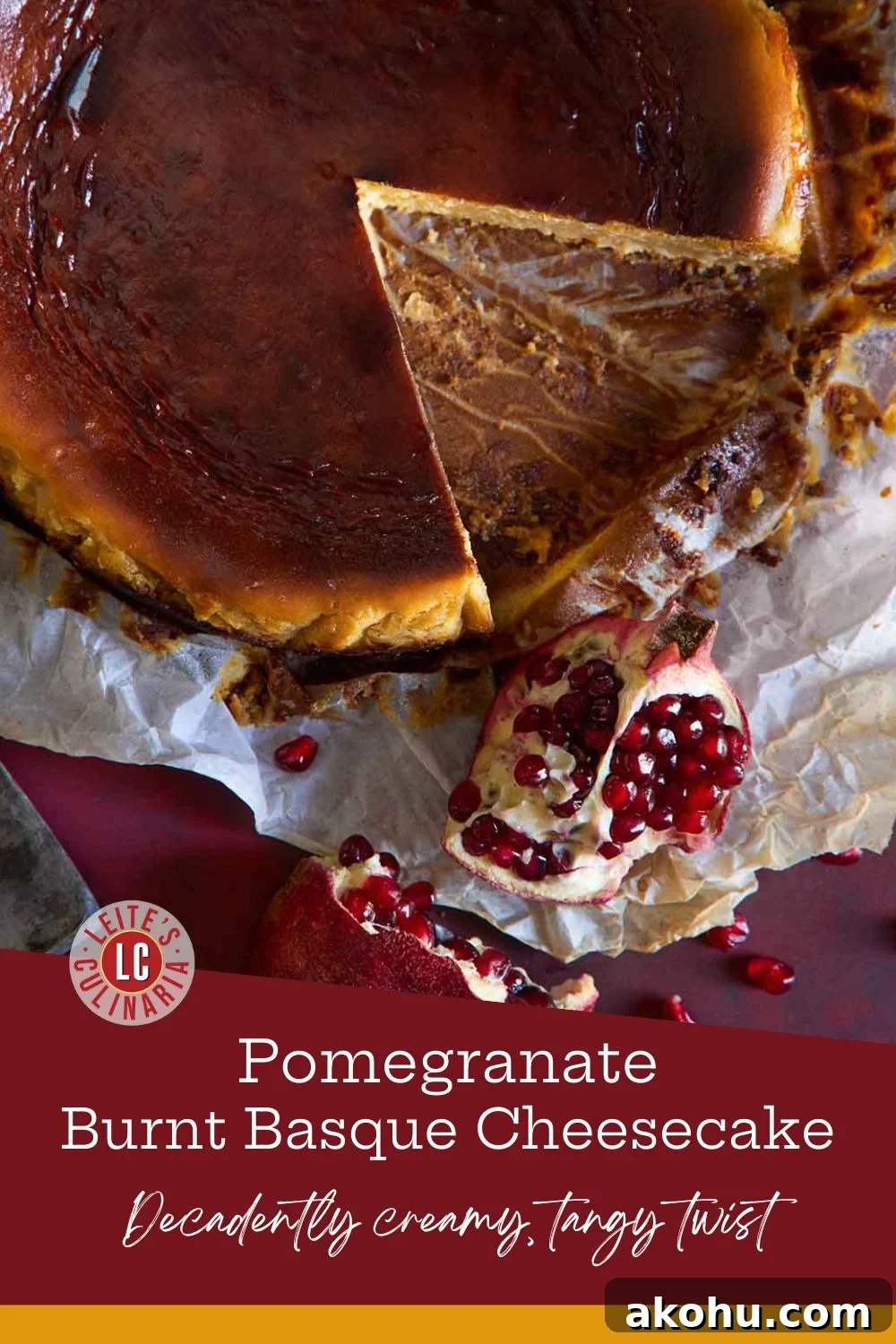 Basque Cheesecake with Tangy Pomegranate Molasses Glaze 3 An overhead shot of a rustic Basque cheesecake with a deep golden-brown top, a slice removed, and a halved pomegranate with a knife next to it on a dark red surface.
