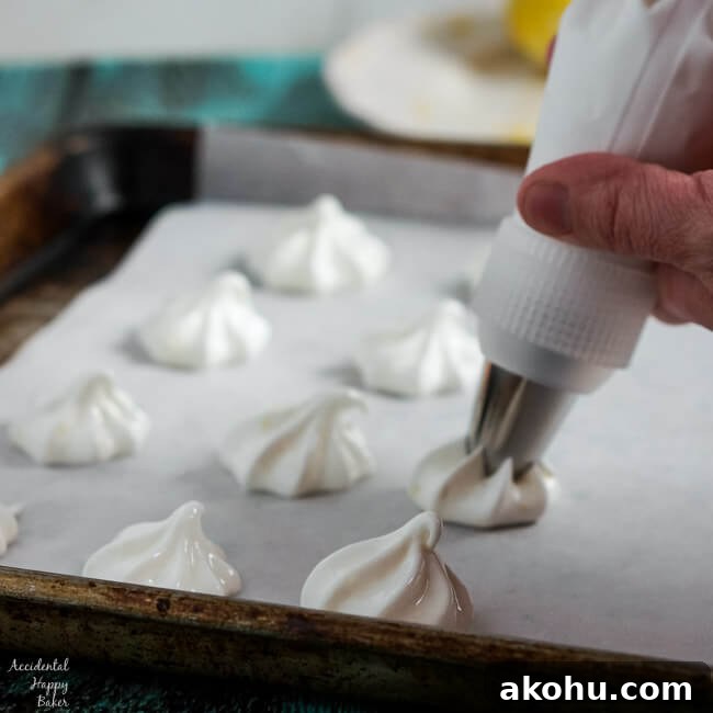 Piping star shaped lemon meringues onto the baking sheet.