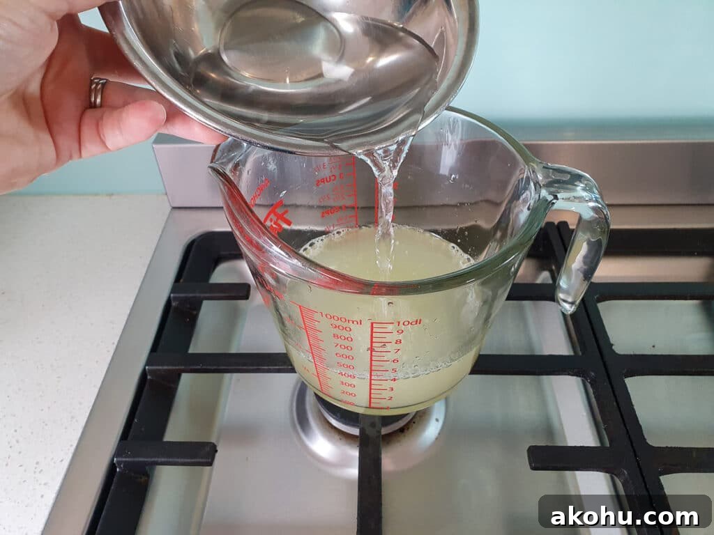Pouring extra water into popsicle mix to top up to two and a half ish cups (600mls).