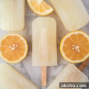 Close up of lemonade popsicles surrounded by fresh lemon slices.