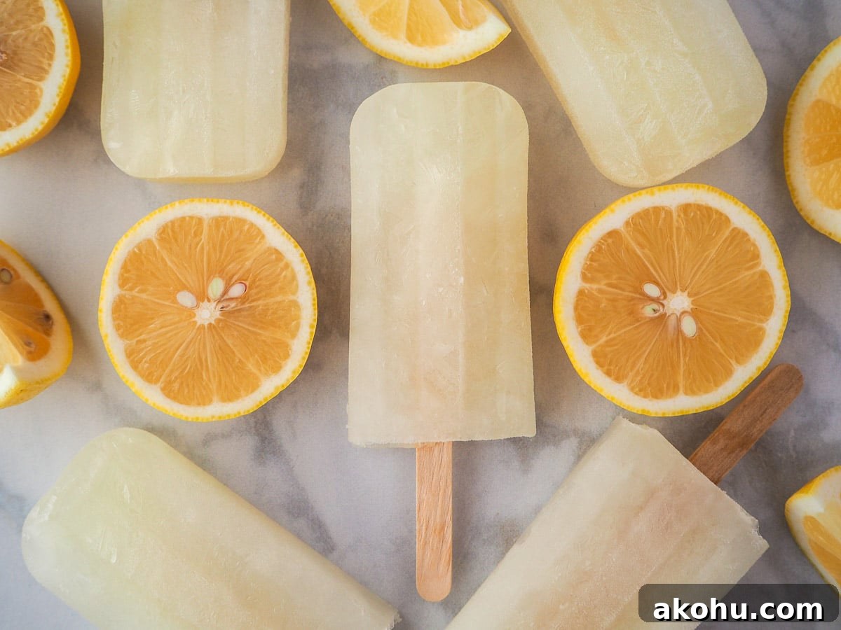 Lemonade popsicles surrounded by fresh lemon slices.