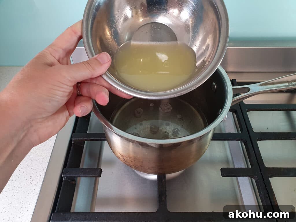 Adding lemon juice to sugar and water mix in pot on stove.