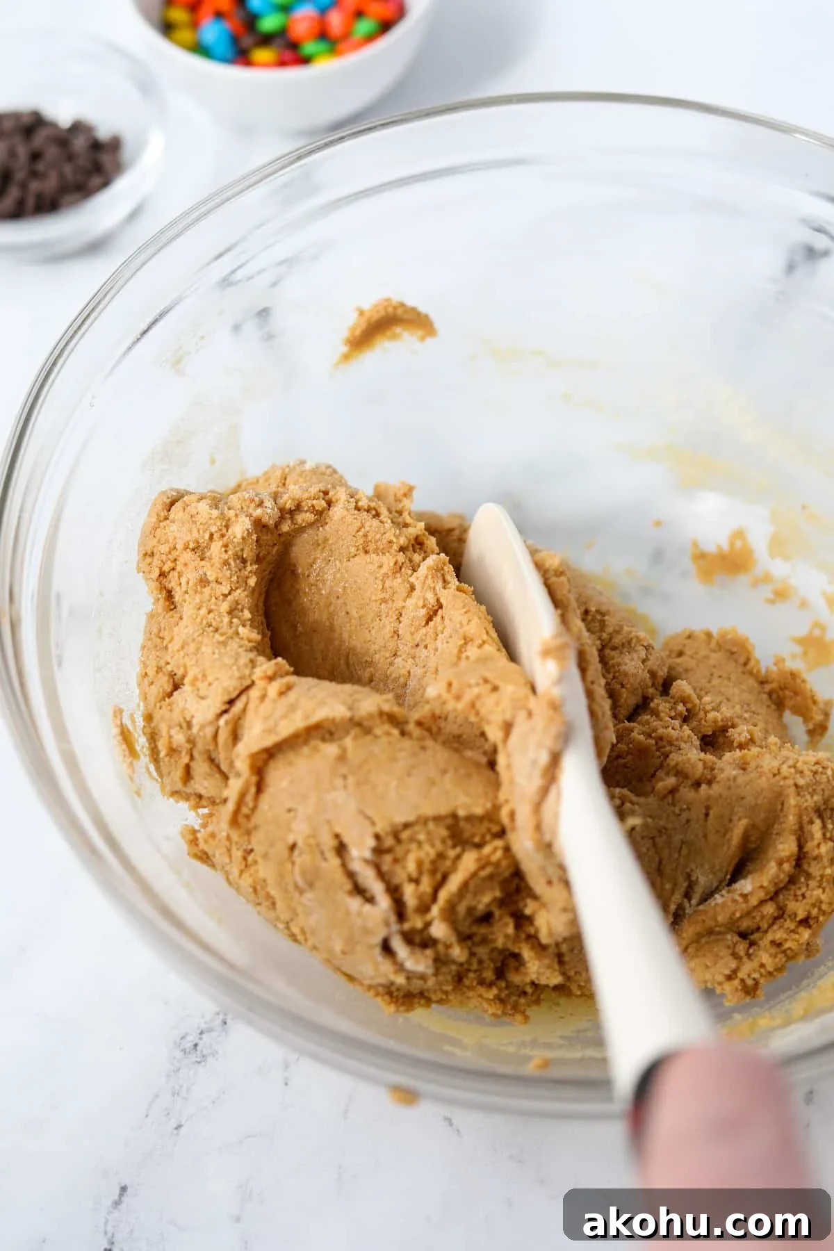 Monster Cookie Protein Bars: Chewy Peanut Butter Oat Bars 6 Mixing together a protein cookie dough in a bowl.