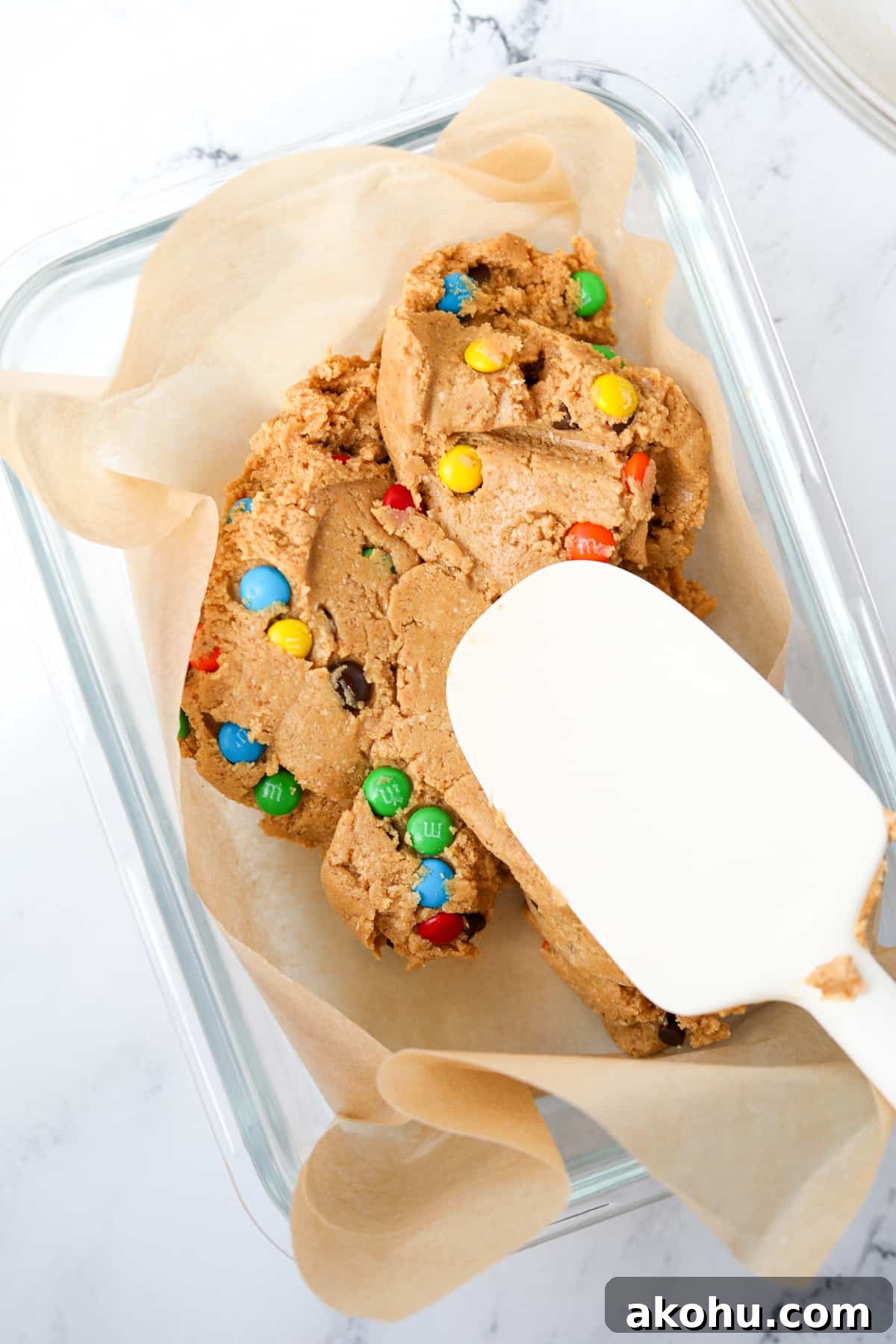 Monster Cookie Protein Bars: Chewy Peanut Butter Oat Bars 8 Spreading a protein bar dough into a parchment lined baking dish.