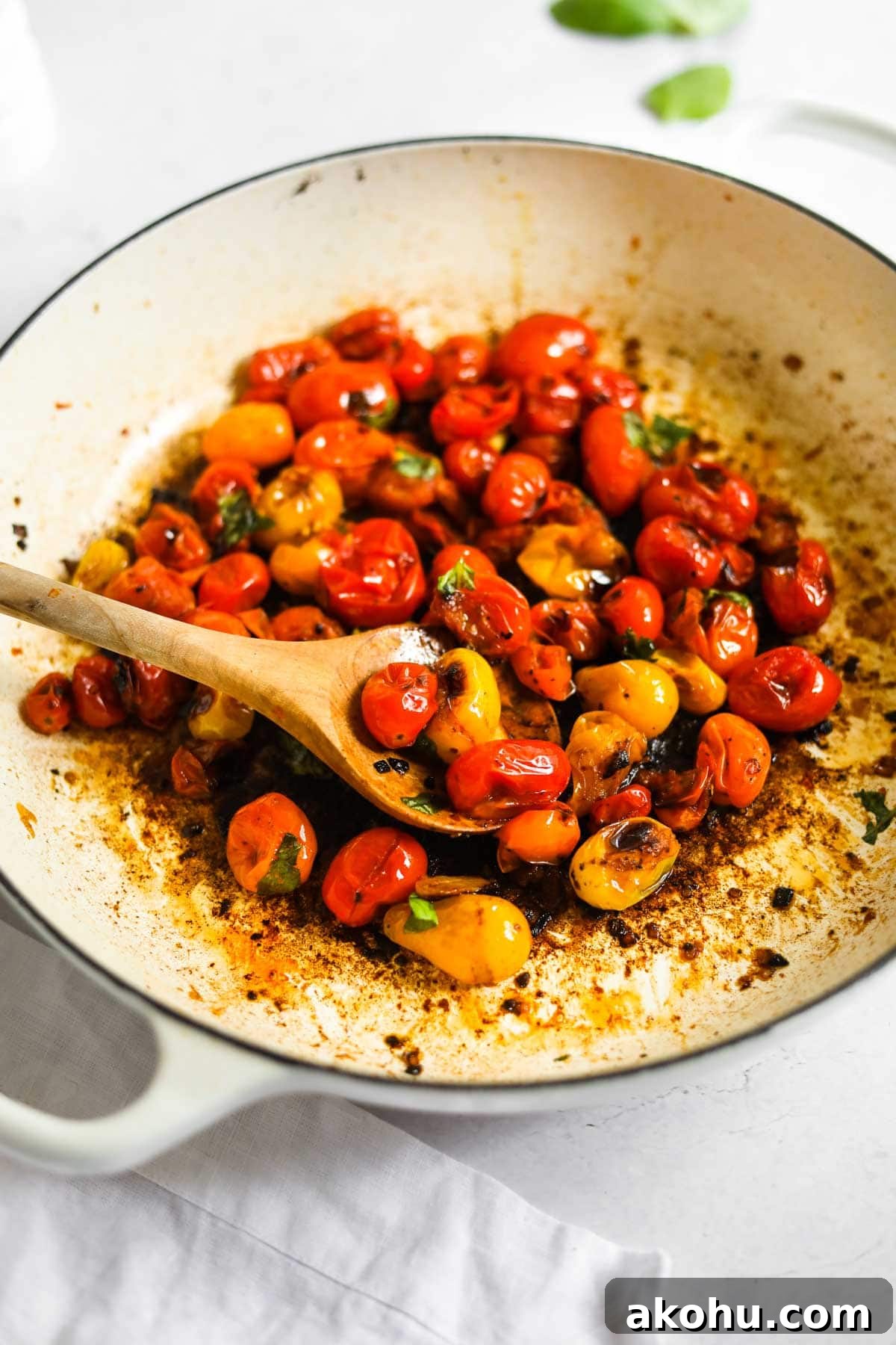 20 Delicious Side Dishes to Serve with Roasted Chicken 20 Blistered Cherry Tomatoes with olive wood spoon and Le Creuset White Braiser.