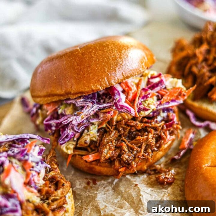 Slow cooker BBQ pulled chicken burgers (sandwiches and sliders) with homemade cabbage coleslaw.