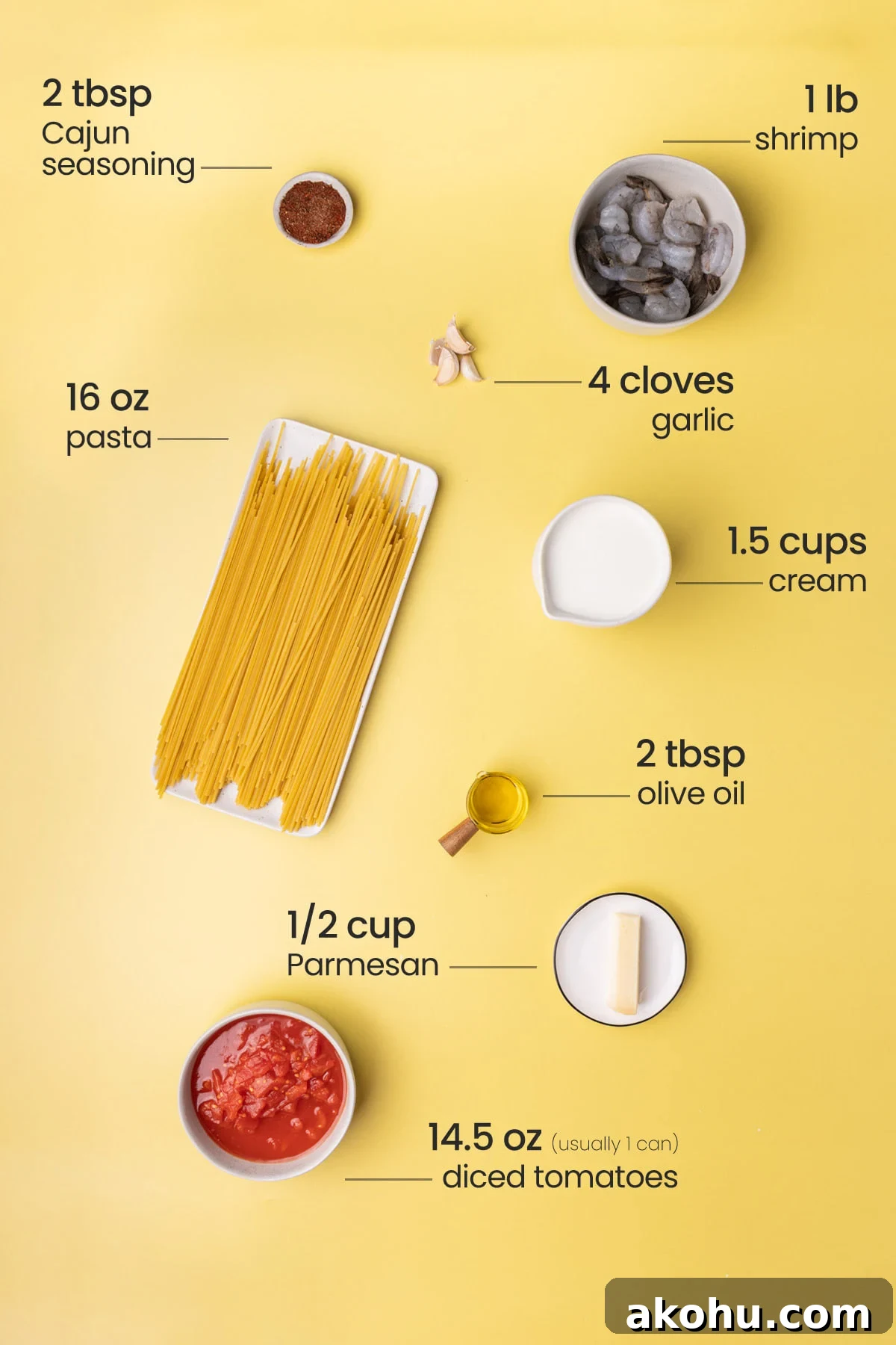 30-Min Cajun Creamy Shrimp Pasta Recipe 3 Overhead view of the ingredients needed for creamy Cajun pasta - Cajun seasoning, shrimp, pasta, garlic, cream, olive oil, Parmesan, and diced tomatoes.