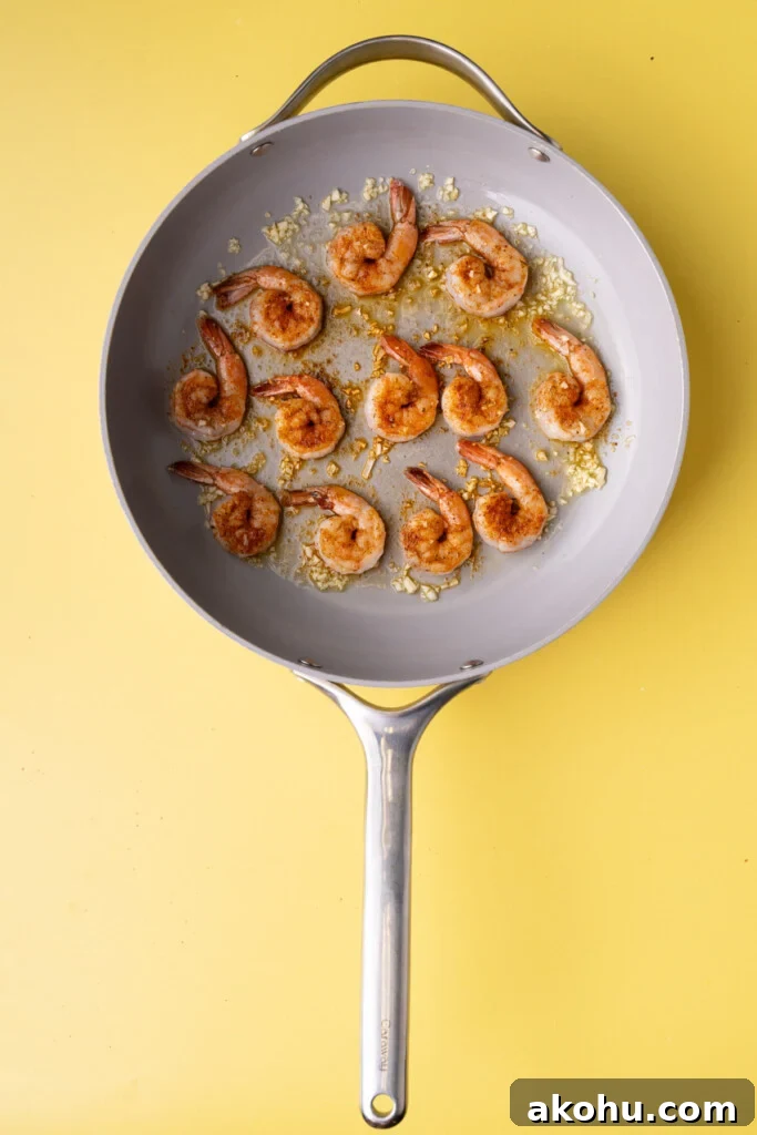 30-Min Cajun Creamy Shrimp Pasta Recipe 5 Shrimp with Cajun seasoning frying in olive oil and garlic.