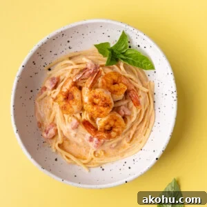 30-Min Cajun Creamy Shrimp Pasta Recipe 8 Creamy Cajun Pasta topped with pan seared shrimp and garnished with fresh basil.