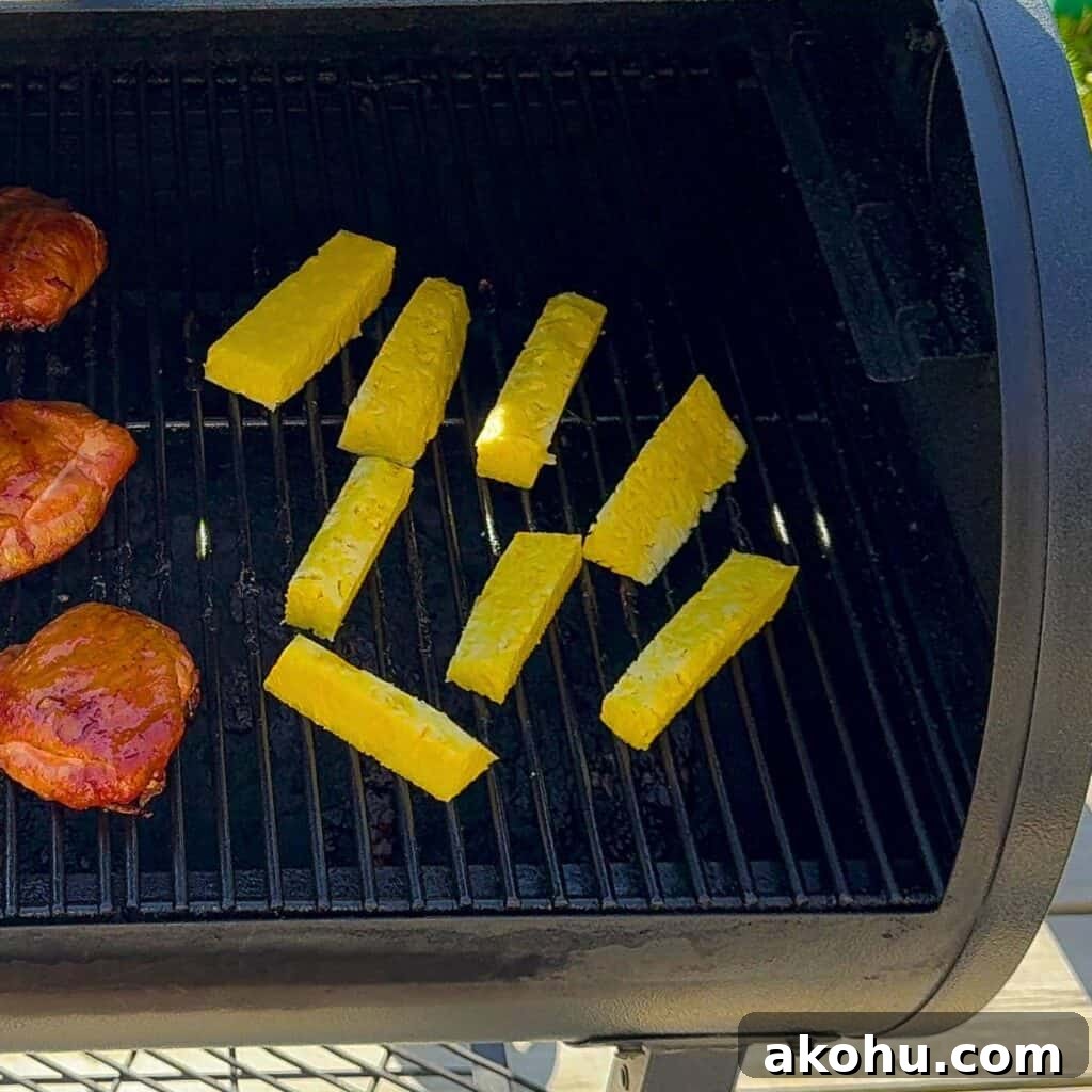 Pineapple spears arranged on smoker grates, spaced out for even smoke circulation.