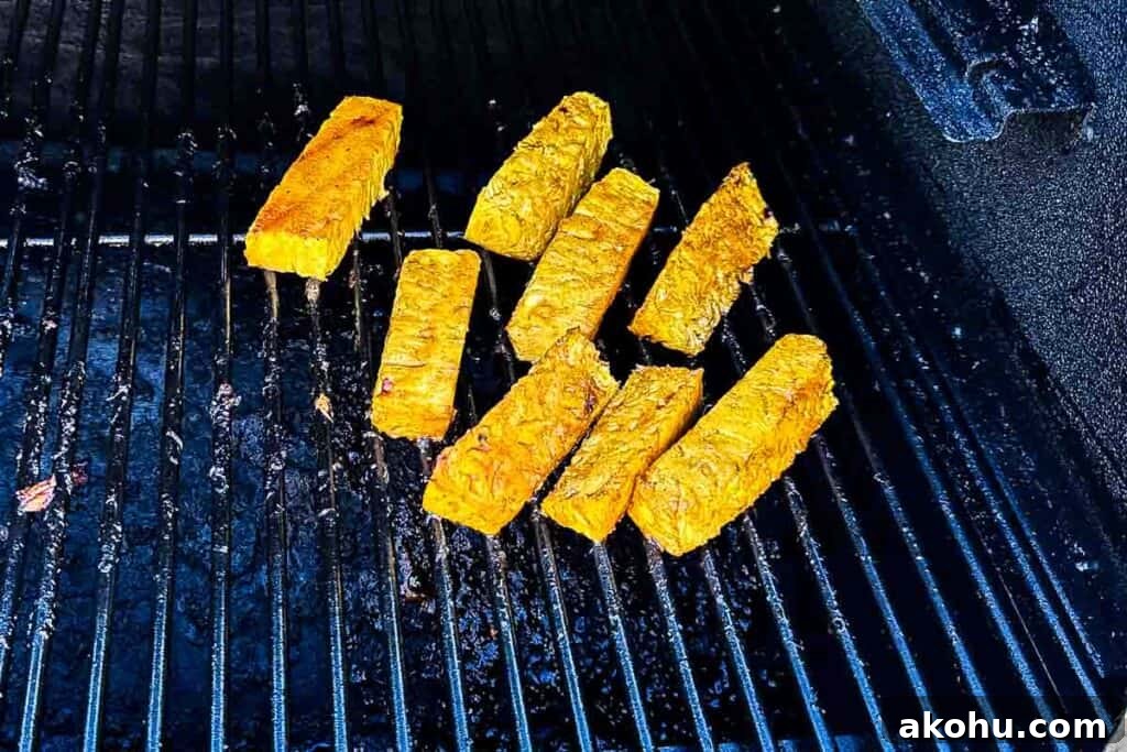 Pineapple spears brushed with cinnamon glaze while smoking in a smoker.