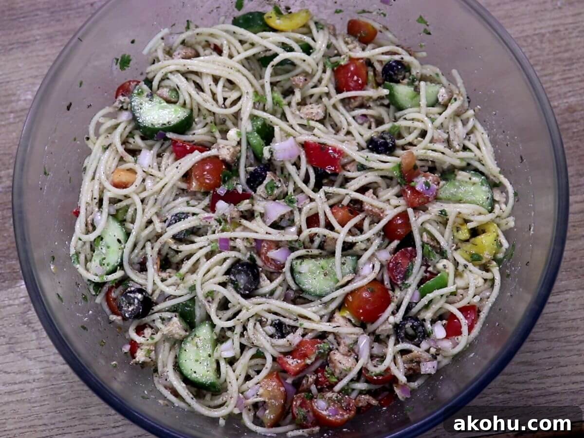 A bowl of mediterranean spaghetti salad with chicken.