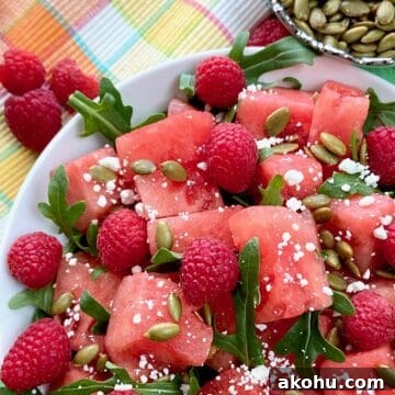 Watermelon, Arugula & Goat Cheese Salad with Balsamic Glaze 4 Watermelon salad garnished with arugula and goat cheese in white bowl.