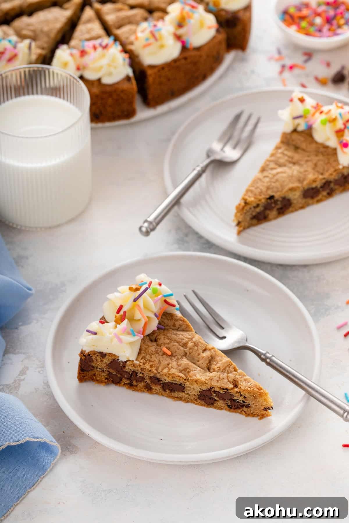 Chocolate Chip Cookie Cake Recipe — Soft, Gooey Dessert King 3 Two white plates, each holding a slice of chocolate chip cookie cake.