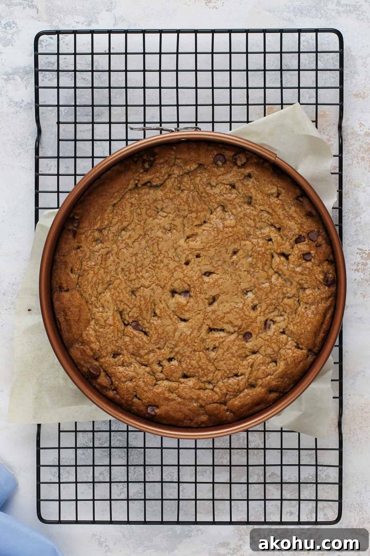 Chocolate Chip Cookie Cake Recipe — Soft, Gooey Dessert King 10 Cooling chocolate chip cookie cake on a wire rack.
