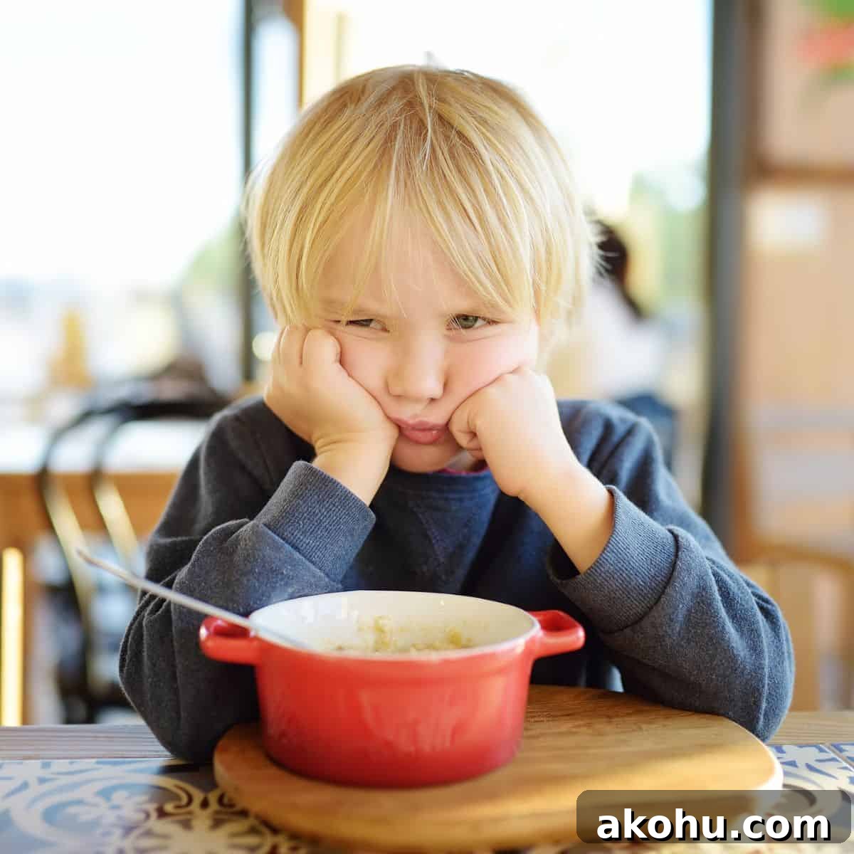 What Causes Picky Eating in Kids — and How to Fix It 3 Little boy with head in hands looking unhappy, not eating from the food bowl on the table